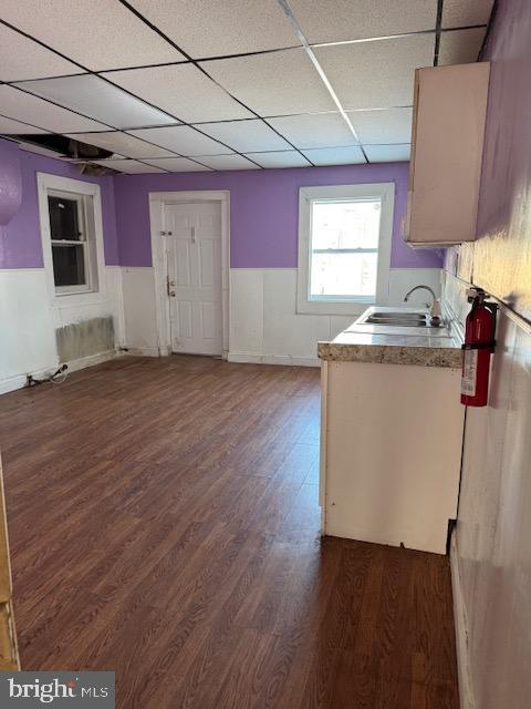 kitchen with dark wood-style floors, light countertops, a drop ceiling, and a sink