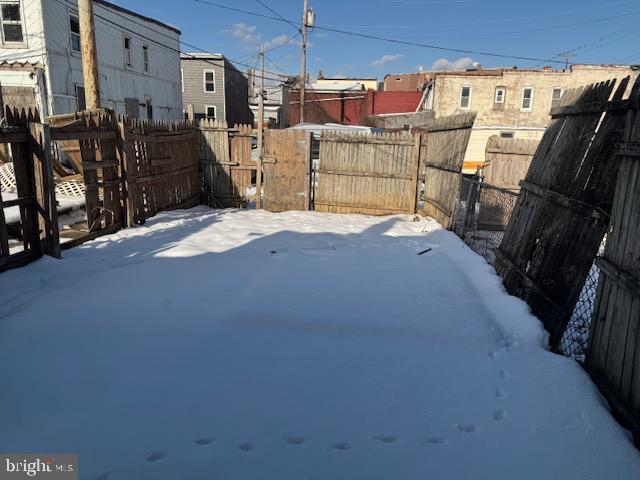 snowy yard featuring fence