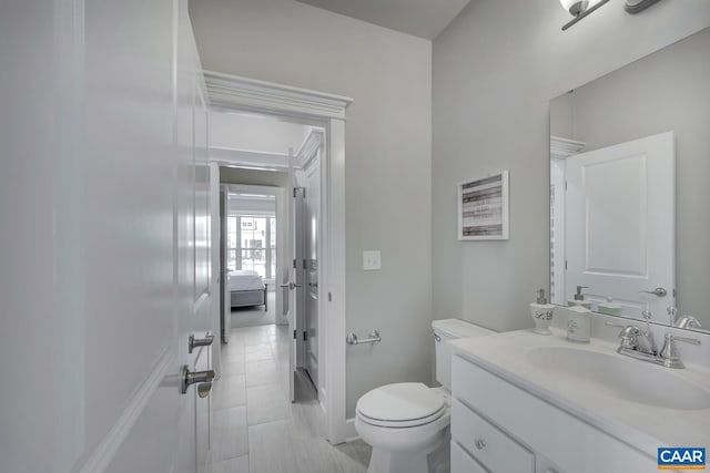 bathroom featuring toilet, vanity, and tile patterned flooring