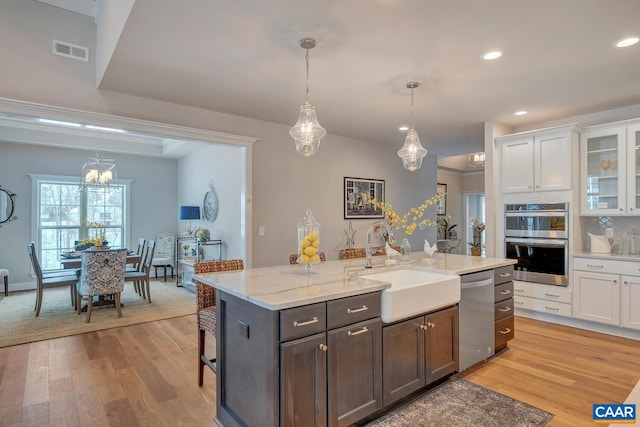 kitchen featuring white cabinets, pendant lighting, stainless steel appliances, and sink