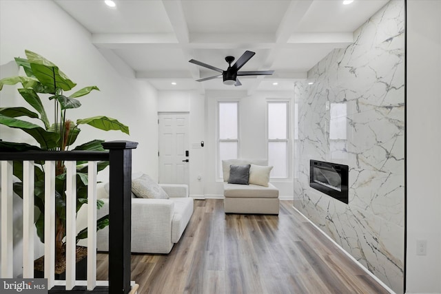 unfurnished living room with coffered ceiling, beam ceiling, a high end fireplace, and wood-type flooring