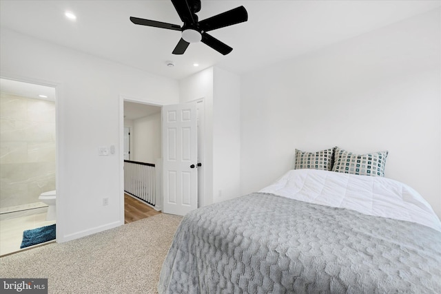 bedroom with ceiling fan, light carpet, and connected bathroom