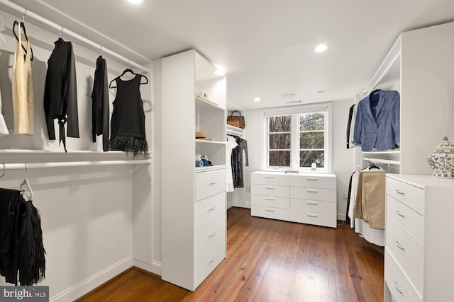 walk in closet with dark wood-style flooring