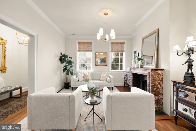 living room with a chandelier, baseboards, crown molding, and light wood finished floors