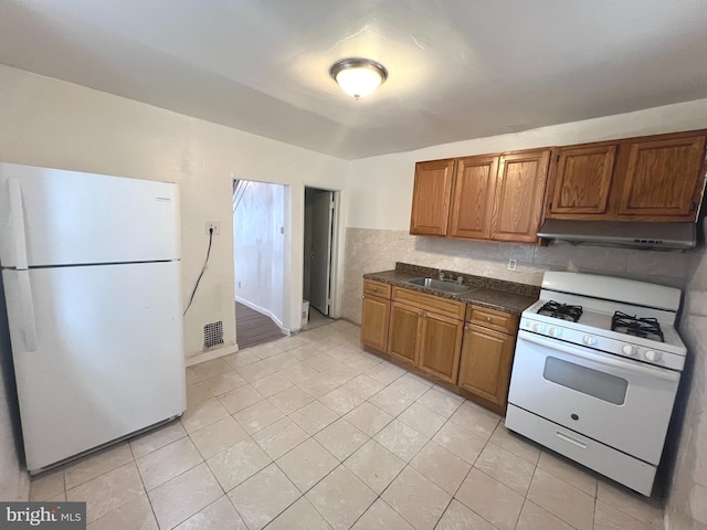 kitchen with white appliances, light tile patterned floors, sink, and backsplash