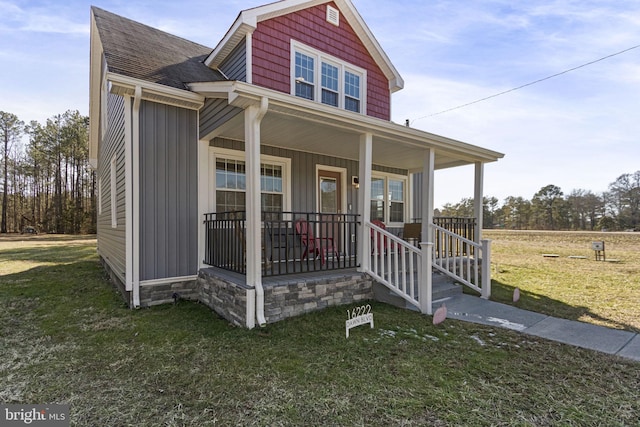 view of front of property featuring roof with shingles, a porch, board and batten siding, and a front yard