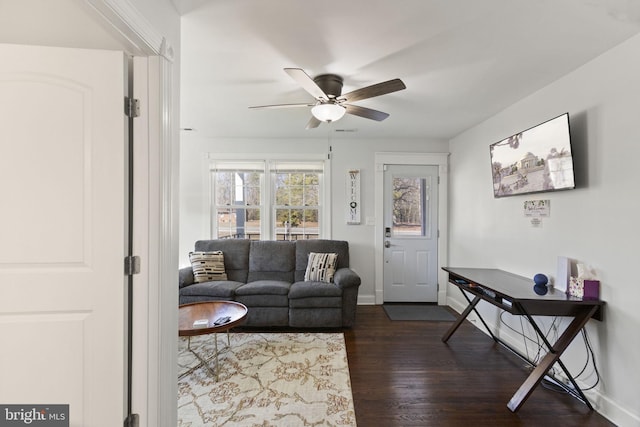 living room featuring ceiling fan, dark wood finished floors, visible vents, and baseboards