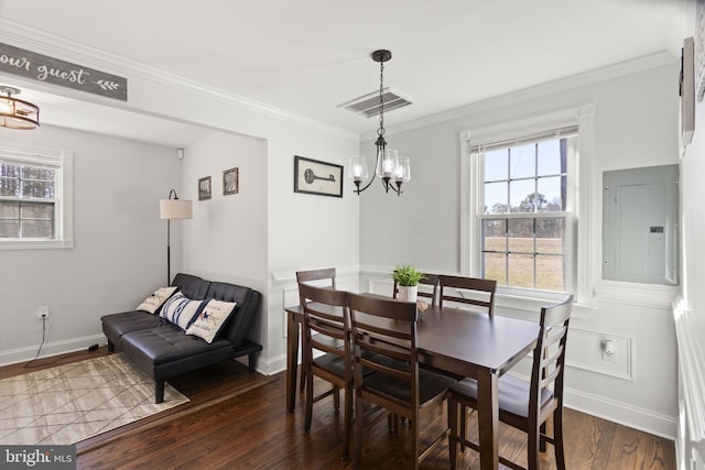 dining room with electric panel, baseboards, visible vents, ornamental molding, and wood finished floors