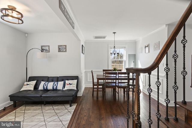 living area with crown molding, stairway, a notable chandelier, and wood finished floors