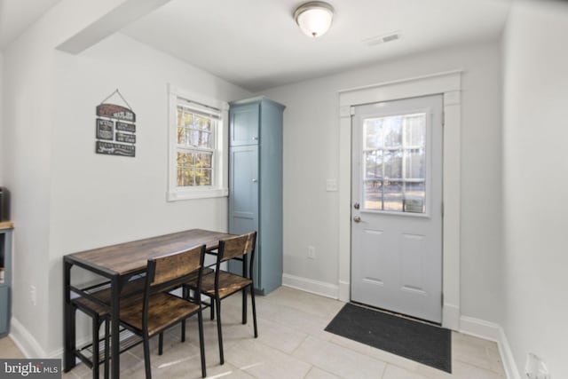 doorway to outside featuring plenty of natural light, visible vents, and baseboards