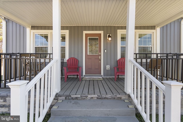 doorway to property with covered porch and board and batten siding