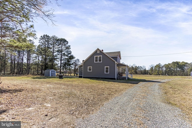 view of side of property with an outbuilding, driveway, and a storage unit