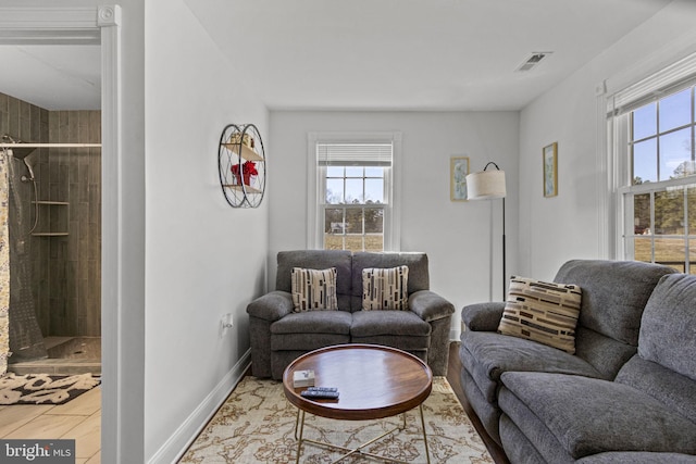 living area with visible vents, a wealth of natural light, and baseboards