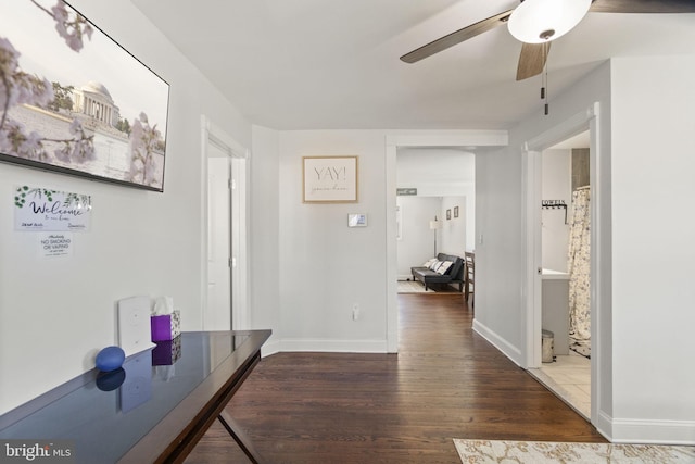 hall featuring dark wood-style floors and baseboards