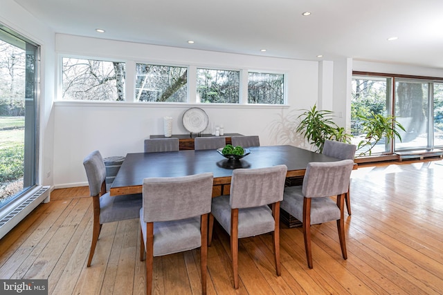 dining room with light wood-type flooring and a baseboard radiator