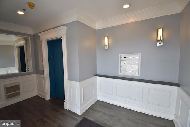 interior space with a wainscoted wall, dark wood-type flooring, mail area, and crown molding