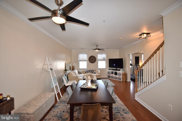 dining room with crown molding, stairs, baseboards, and wood finished floors