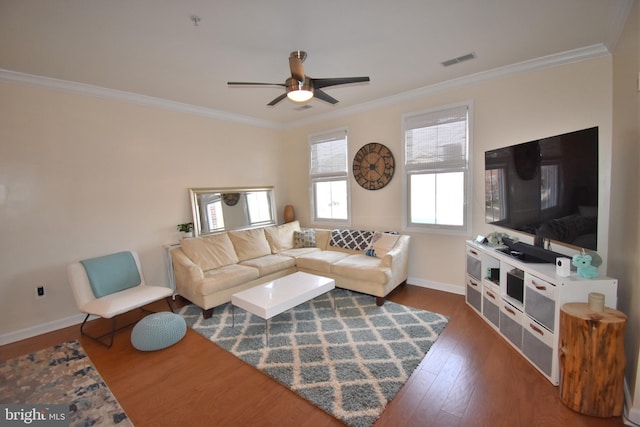 living room with baseboards, visible vents, dark wood finished floors, ceiling fan, and crown molding