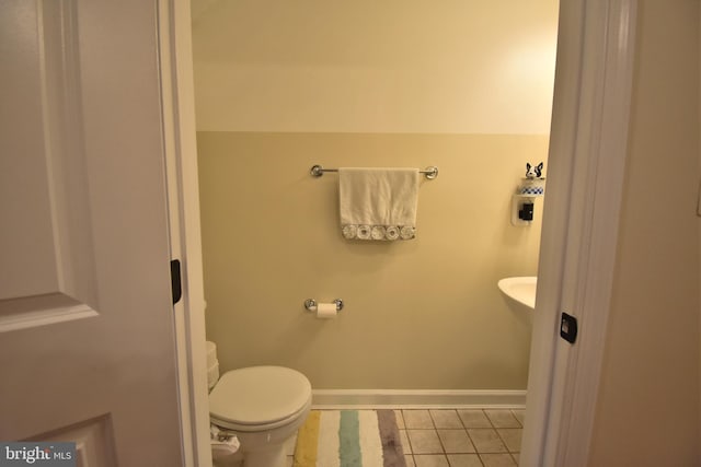 bathroom featuring baseboards, toilet, and tile patterned floors