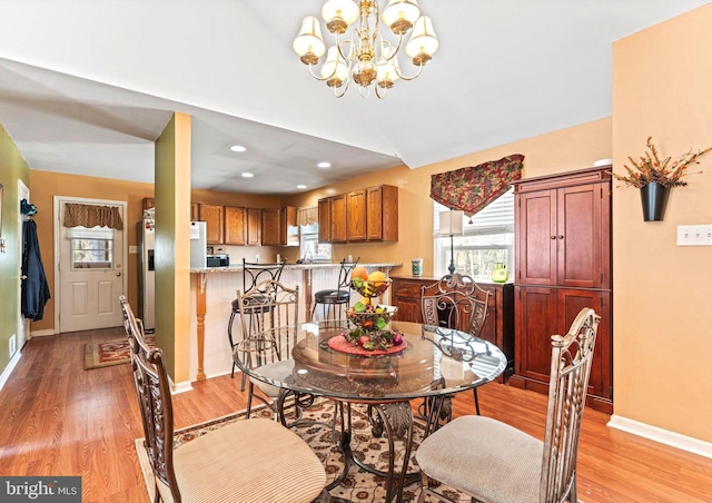 dining space with light wood-style floors, recessed lighting, a chandelier, and baseboards