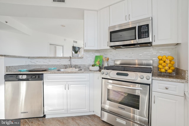 kitchen featuring white cabinets, stainless steel appliances, and a sink