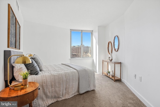 carpeted bedroom featuring visible vents and baseboards