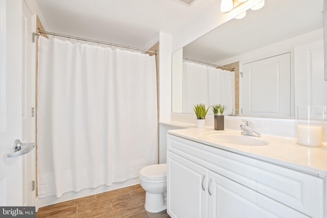 bathroom featuring wood finish floors, visible vents, vanity, and toilet