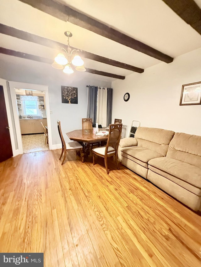 dining space with hardwood / wood-style floors, a chandelier, and beam ceiling