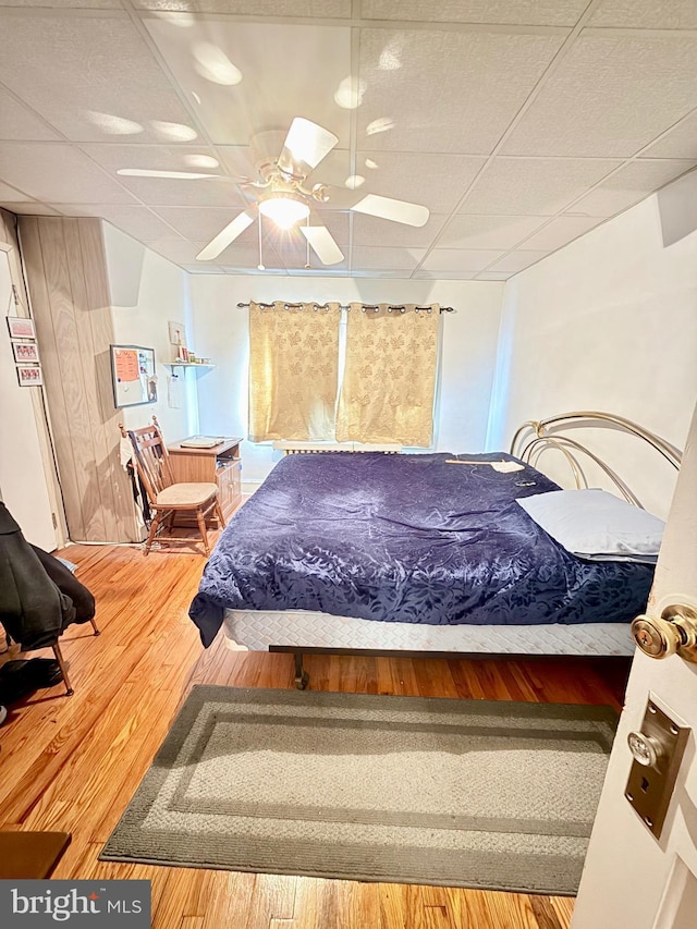 bedroom featuring hardwood / wood-style flooring and a drop ceiling