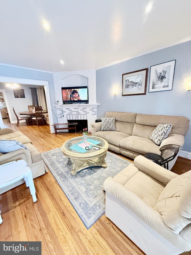 living room with hardwood / wood-style flooring and a brick fireplace