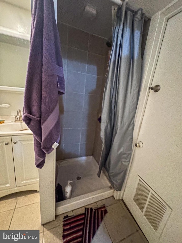 bathroom with a shower stall, visible vents, tile patterned flooring, and vanity