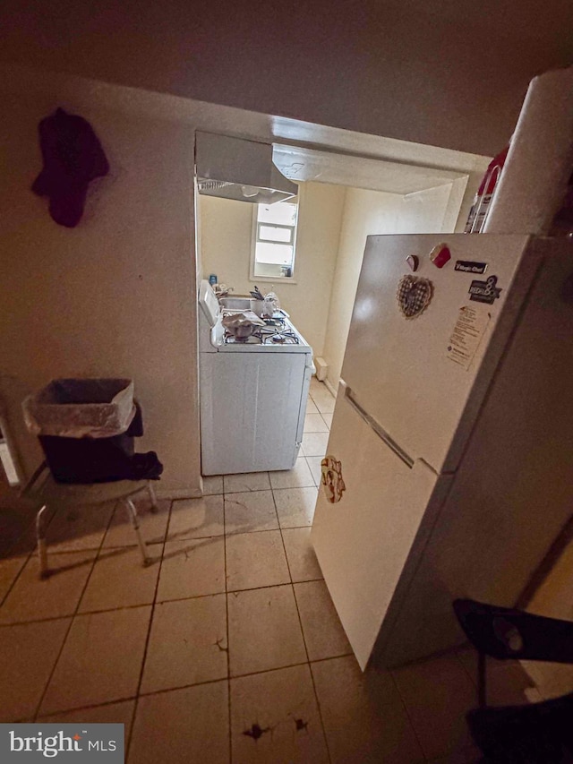 kitchen with white appliances and light tile patterned floors