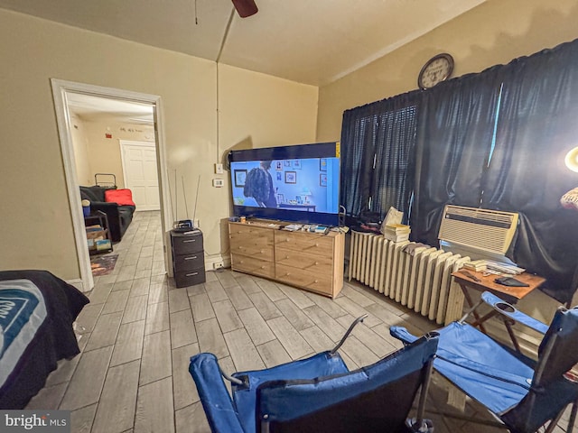 interior space featuring wood tiled floor, cooling unit, ceiling fan, and radiator heating unit