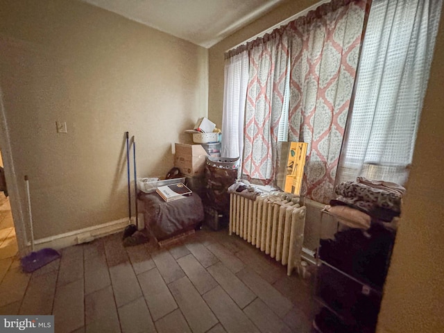 miscellaneous room featuring radiator heating unit, wood finished floors, and baseboards