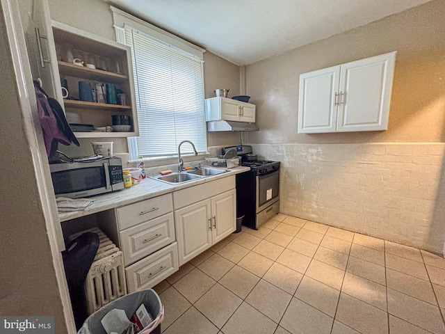 kitchen with light countertops, appliances with stainless steel finishes, a sink, and white cabinetry