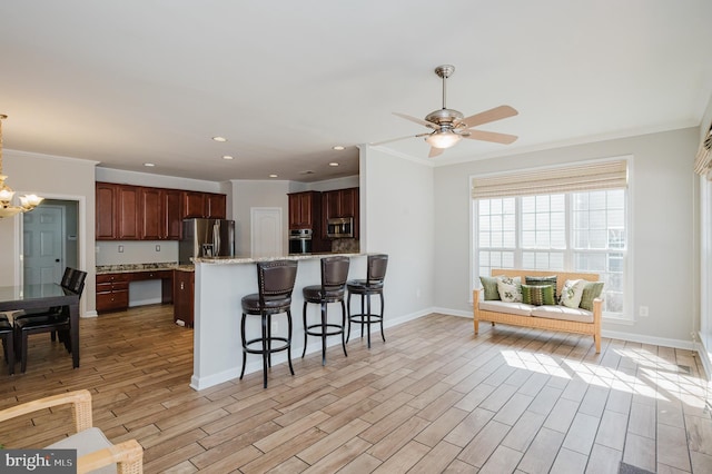 kitchen with recessed lighting, a breakfast bar, appliances with stainless steel finishes, light wood finished floors, and crown molding