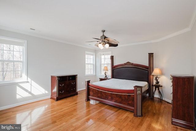 bedroom featuring baseboards, visible vents, ceiling fan, ornamental molding, and light wood-style floors