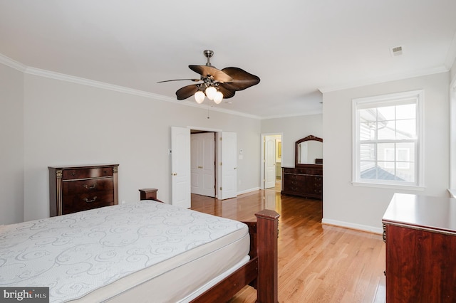 bedroom featuring baseboards, light wood-style flooring, and crown molding