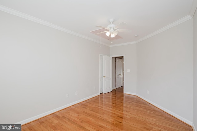 empty room featuring baseboards, ornamental molding, attic access, and light wood-style floors