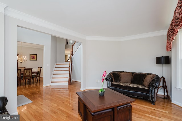 living area with ornamental molding, an inviting chandelier, light wood finished floors, and stairs