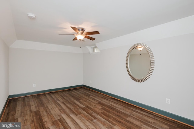 empty room with dark wood-type flooring, baseboards, and a ceiling fan