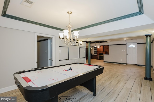 playroom featuring wood tiled floor, visible vents, crown molding, and baseboards