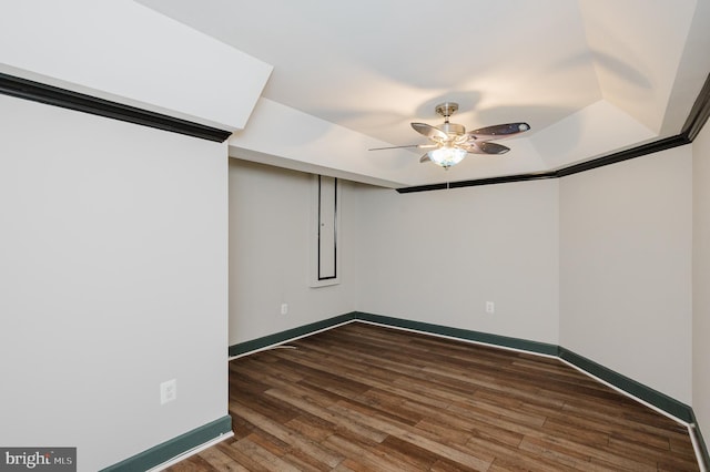 unfurnished room with ceiling fan, baseboards, and dark wood-type flooring