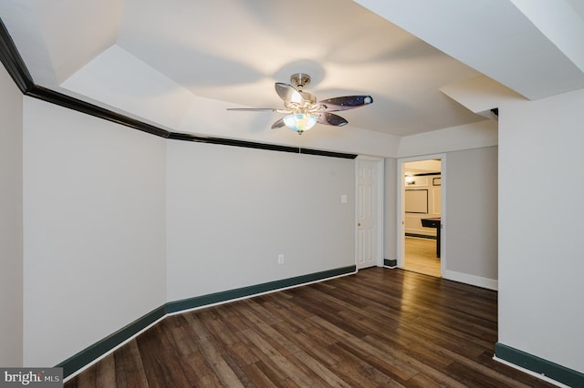 unfurnished room featuring a ceiling fan, baseboards, and dark wood-type flooring