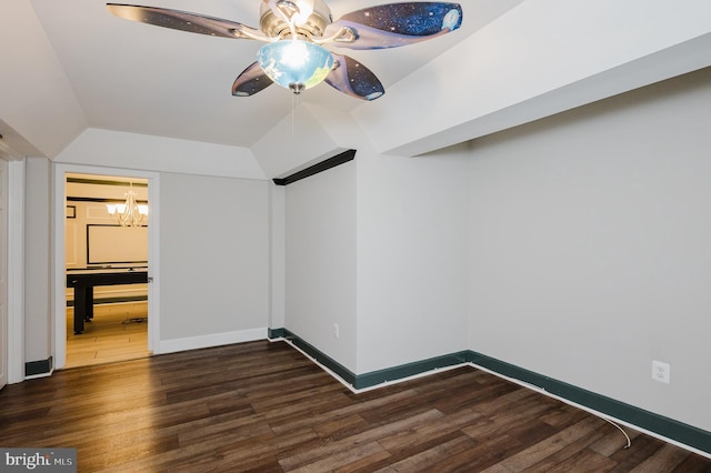 interior space with ceiling fan with notable chandelier, dark wood finished floors, and baseboards