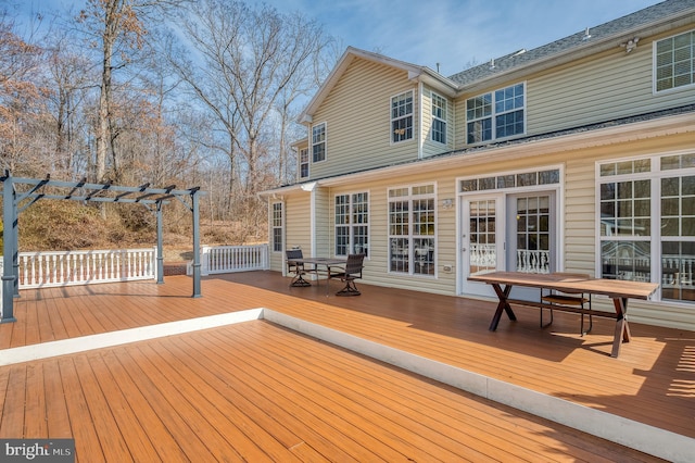 wooden terrace featuring outdoor dining area and a pergola