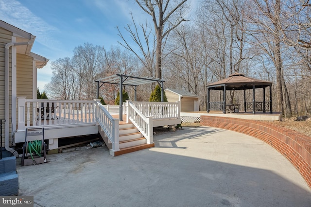 exterior space with a wooden deck, a storage unit, an outdoor structure, and a gazebo