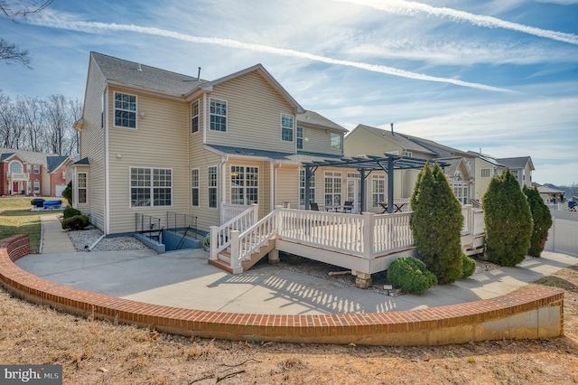 rear view of house with a patio area, a wooden deck, and a pergola