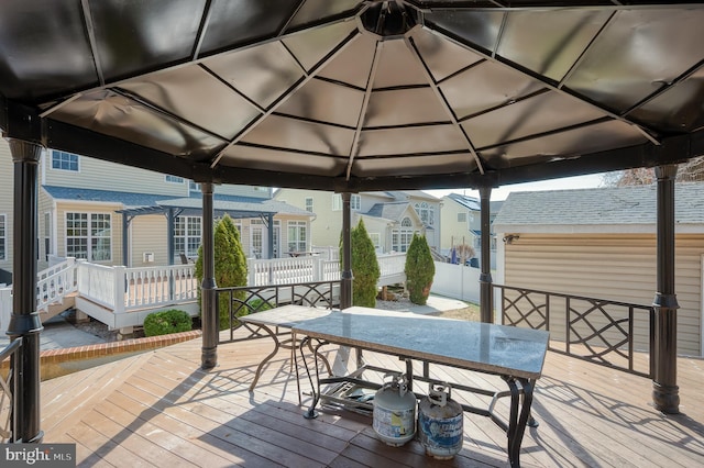 deck featuring a gazebo, outdoor dining space, and fence