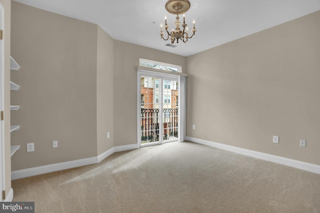 carpeted empty room featuring visible vents, baseboards, and an inviting chandelier